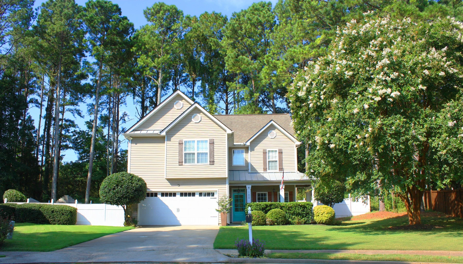 The front of the Darling House in Senoia, with a teal front door and landscaped lawn